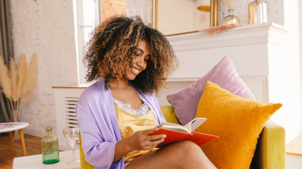 a person reading a book while sitting on a couch