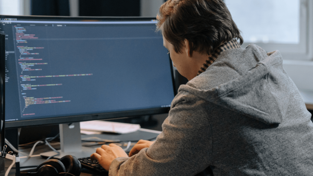 a person is working on a computer in front of a monitor