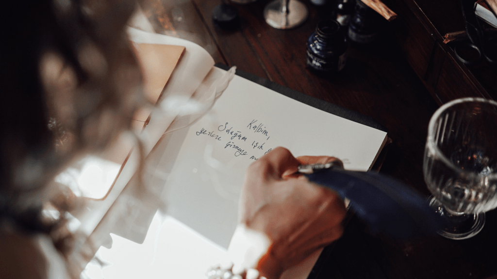 a person writing on a piece of paper with a pen