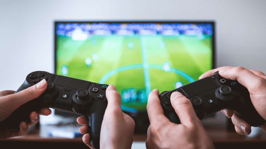 a person holding a video game controller in front of a television