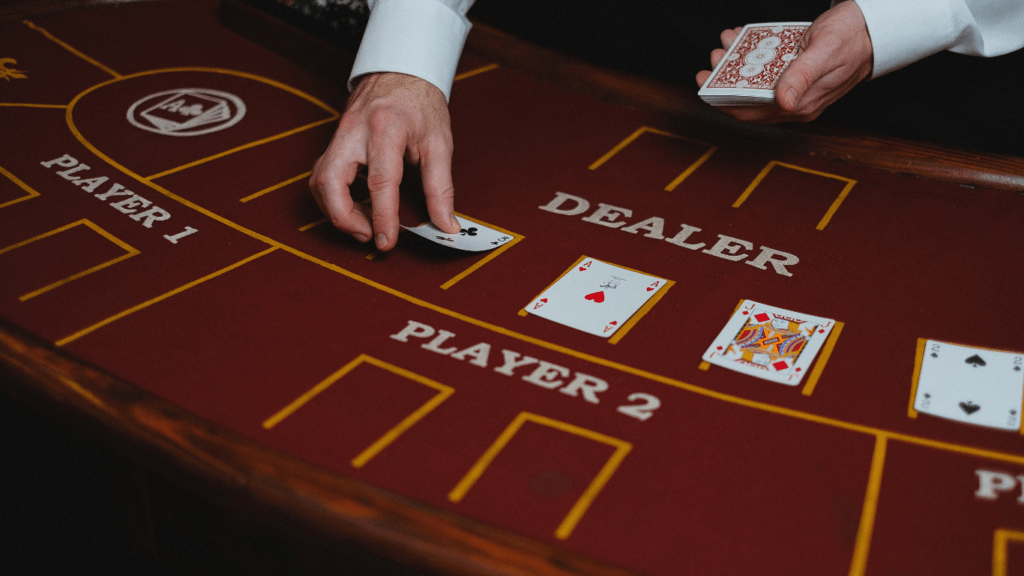 a person in a suit and tie playing cards at a casino table