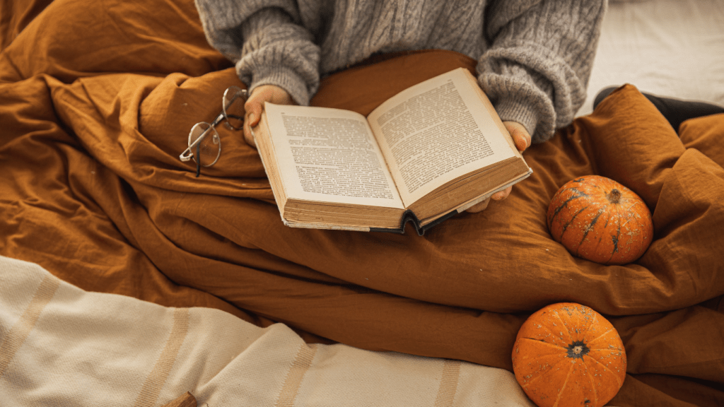 a person reading a book while sitting on a couch