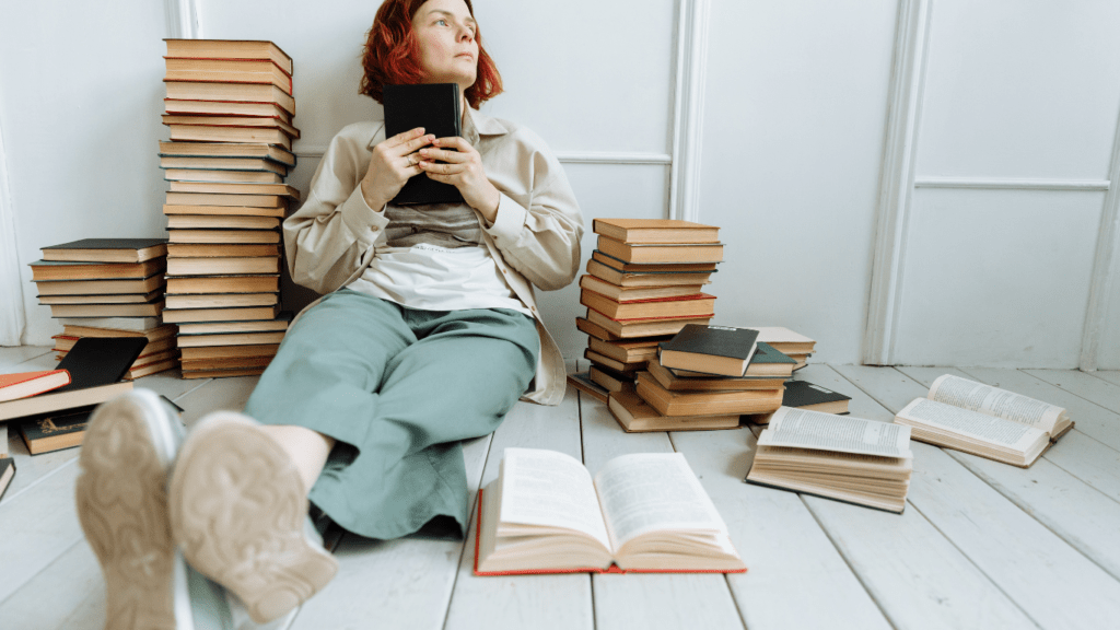 a person sitting on top of a stack of books