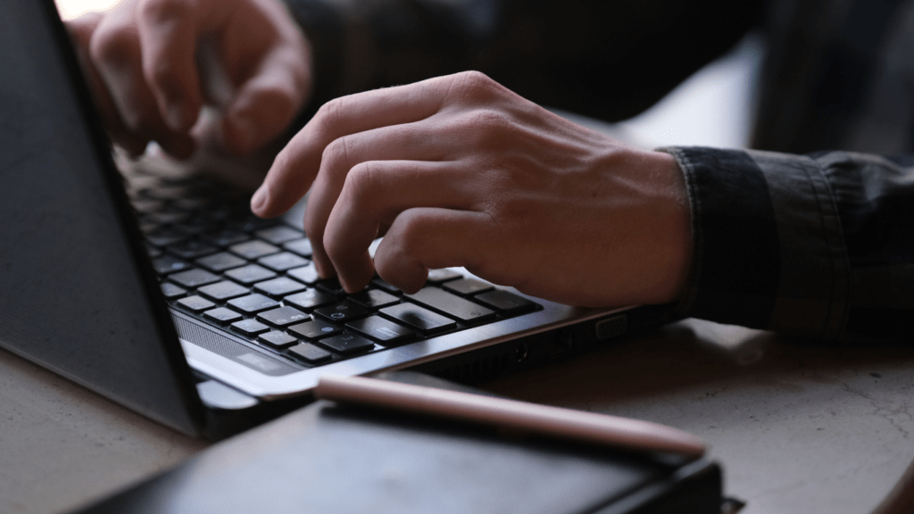 a person typing on a laptop computer