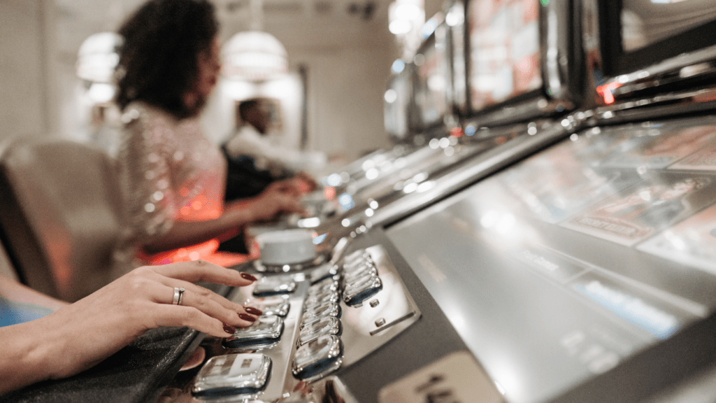 two people sitting in front of slot machines in a casino